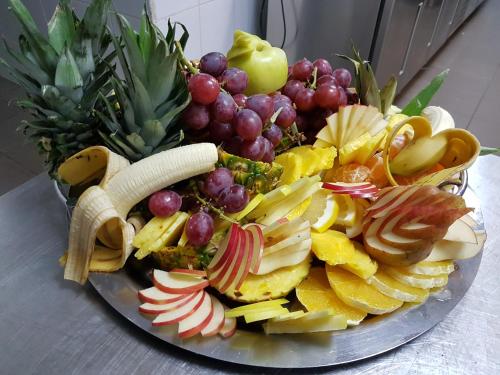 a plate of fruit and vegetables on a table at Hotel Magic - City Center in Piteşti