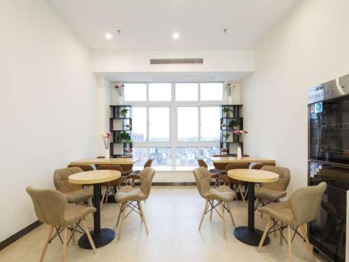 una stanza con tavoli e sedie e una grande finestra di 7Days Premium Chongqing Liangping People's Square Center Branch a Liangping