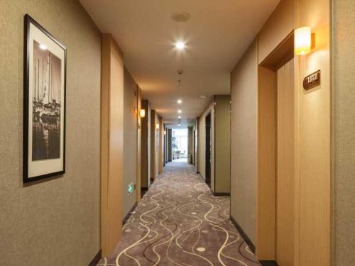 un corridoio di un hotel con un lungo corridoio di 7Days Premium Chongqing Liangping People's Square Center Branch a Liangping