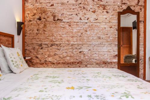 a bed in a room with a brick wall at Casa da Tita in Salir