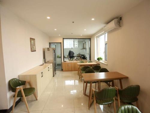a kitchen and dining room with tables and chairs at 7Days Premium Hengshui Shenzhou City Government Branch in Hengshui