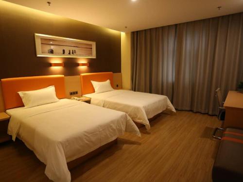 a hotel room with two beds and a window at 7Days Premium Hengshui Shenzhou City Government Branch in Hengshui