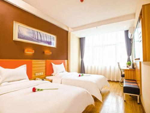 um quarto de hotel com duas camas e uma janela em 7Days Premium Luoyang Yichuan Dukang Avenue Branch em Luoyang