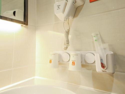 baño con lavabo y teléfono en la pared en 7Days Premium Jinan Beiyuan Street Red Star Macalline Branch en Jinan
