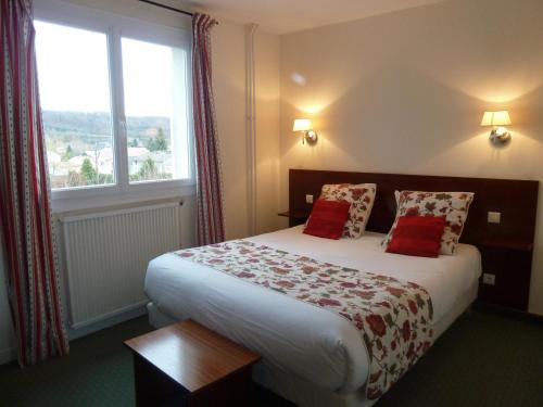 una camera d'albergo con un letto e una grande finestra di Hotel Des Voyageurs a Le Rouget