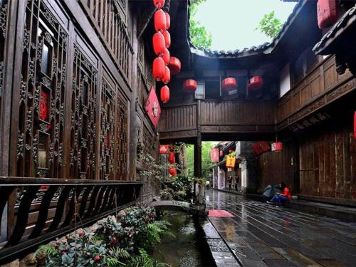 un cortile di un edificio con fiori e lanterne rosse di 7Days Premium Chengdu Yulin South Street Branch a Chengdu