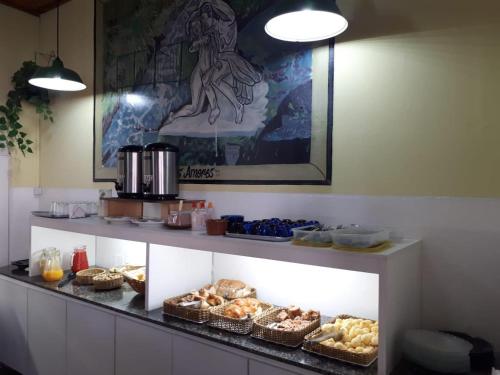 a display case with pastries and other food items at Hotel Planalto in Poços de Caldas