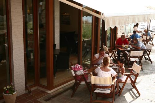 a group of people sitting at tables outside a restaurant at Fjord B&B in Sozopol