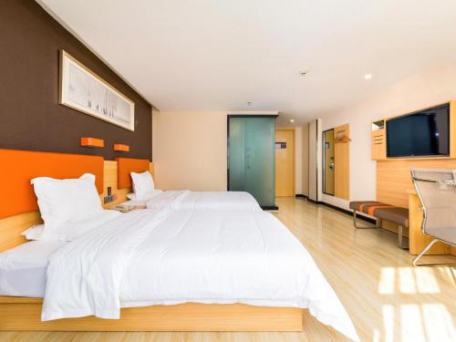 une chambre d'hôtel avec un grand lit et une télévision à écran plat dans l'établissement 7 Days Premium Sanya Bay Haiyue Plaza Foreign Trade Road Food Street Branch, à Sanya