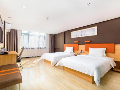 une chambre d'hôtel avec deux lits et un bureau dans l'établissement 7 Days Premium Sanya Bay Haiyue Plaza Foreign Trade Road Food Street Branch, à Sanya