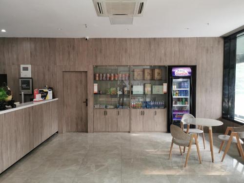 a restaurant with a counter and a table and chairs at 7Days Premium Jiyuan Tiantai Road Xinyao City Square Branch in Jiyuan