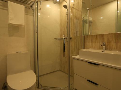 y baño con ducha, aseo y lavamanos. en 7Days Premium Xi'ning Dashizi Center Branch en Xining