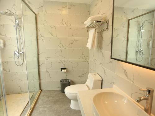 a bathroom with a toilet and a shower and a sink at 7Days Premium Xi'ning Dashizi Center Branch in Xining