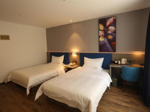 a hotel room with two beds and a painting on the wall at 7Days Premium Xi'ning Dashizi Center Branch in Xining