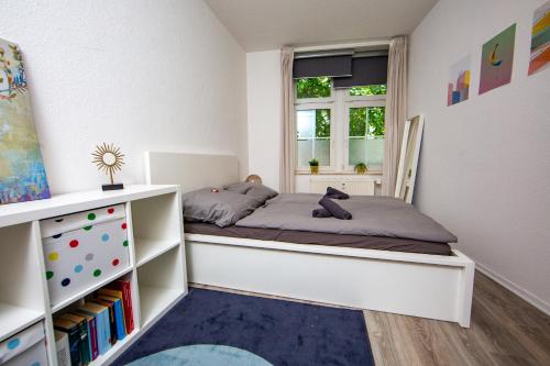 Habitación pequeña con cama y ventana en Ruhiges City Apartment "Altbauperle" mit Charme und 2 Schlafzimmern, en Erfurt