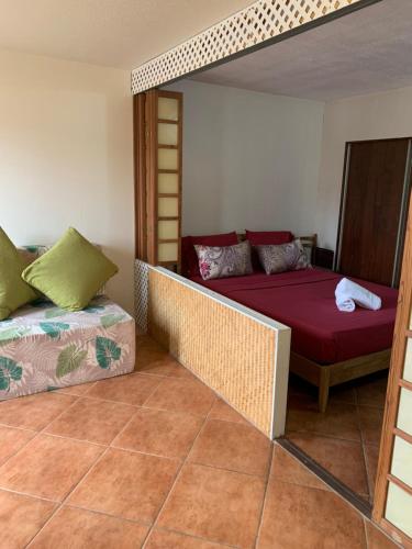 a bedroom with a bed and a couch in a room at F2 Tapu in Papeete