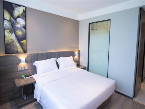 Una cama o camas en una habitación de 7Days Premium Mianyang Donghu Park Branch