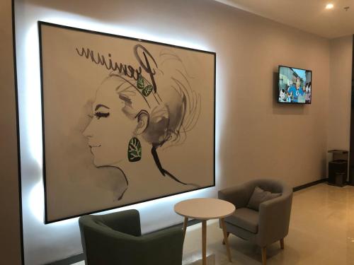 a living room with a large painting of a woman at 7Days Premium Huaian Zhou Enlai Memorial Hall Yuanhuai East Road Branch in Hexia