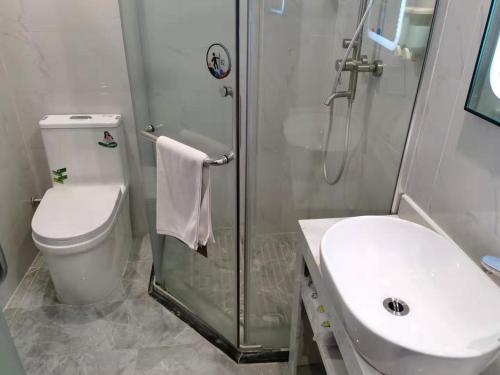 a bathroom with a toilet and a shower and a sink at 7Days Premium Guangzhou Guangyuan Coach Station Branch in Guangzhou