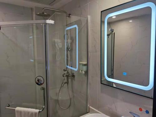ein Badezimmer mit einer Dusche mit einer Glasdusche an der Hintertür in der Unterkunft 7Days Premium Guangzhou Guangyuan Coach Station Branch in Guangzhou