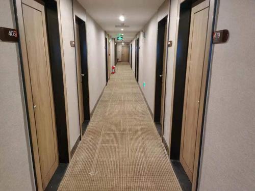 a hallway with doors and a long aisle of stalls at 7Days Premium Guangzhou Guangyuan Coach Station Branch in Guangzhou