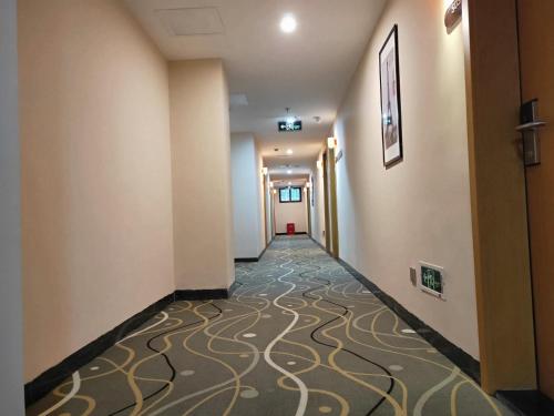 a hallway of a hotel with a carpeted corridor at 7Days Premium Chenzhou Xinglong Pedestrian Street Branch in Chenzhou