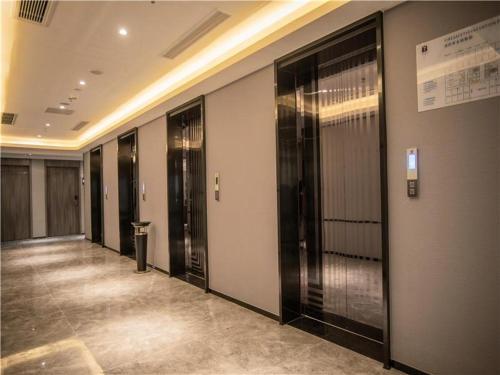 a hallway with many elevators in a building at 7Days Premium Chongqing North Train Station North Square Center Branch in Chongqing