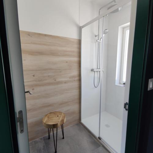 a bathroom with a shower and a wooden stool at Kukamona in O Pino 