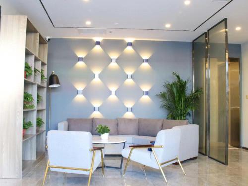 a living room with a couch and a table at 7Days Premium Xiong'an New District Rongcheng Baiyangdian Branch in Baoding