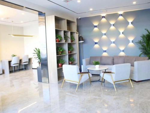 a lobby with a couch and a table and chairs at 7Days Premium Xiong'an New District Rongcheng Baiyangdian Branch in Baoding