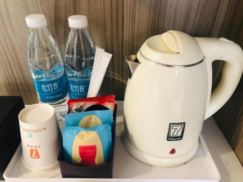 - une cafetière et des bouteilles d'eau sur une étagère dans l'établissement 7Days Premium Xingyi Pingdong Avenue Branch, à Xiawutun