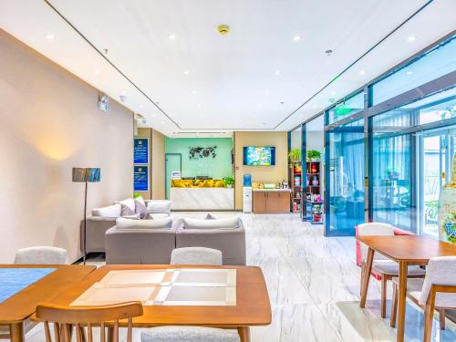 a living room with a couch and tables at 7Days Premium Beijing Zhongguancun Renmin University Suzhou Street Subway Station Branch in Beijing