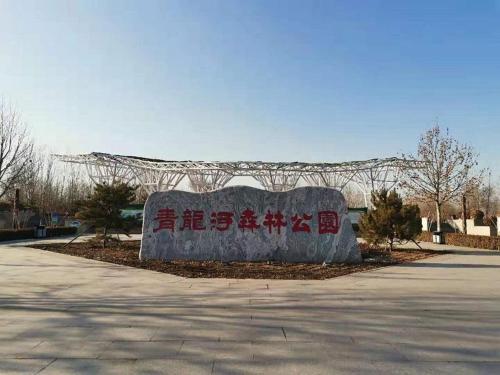 a large stone sign sitting in a parking lot at 7Days Premium Qinhuangdao Lulong Bus Station Yongwang Avenue Branch in Qinhuangdao