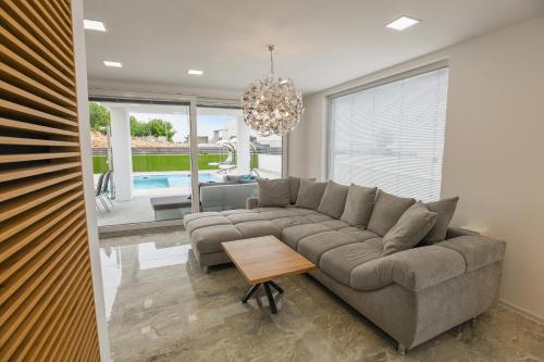 a living room with a couch and a chandelier at SPA House in Crikvenica