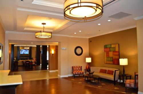 a living room with a couch and a clock on the wall at Holiday Inn Express & Suites - Smithfield/Selma by IHG in Smithfield