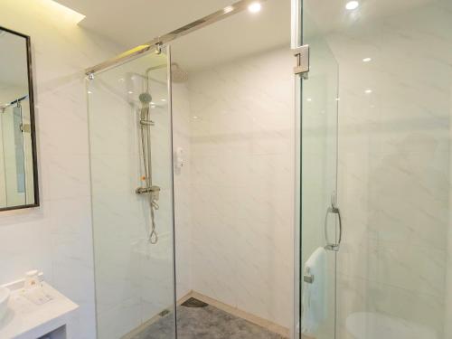 y baño con ducha y puerta de cristal. en 7Days Premium Yibin North Gate Bus Station Branch, en Yibin