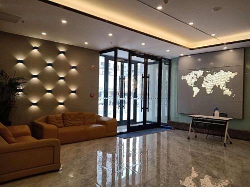 un vestíbulo con sofá y mesa y un mapa mundial en la pared en 7Days Premium Jinzhou Railway Station Branch, en Jinzhou