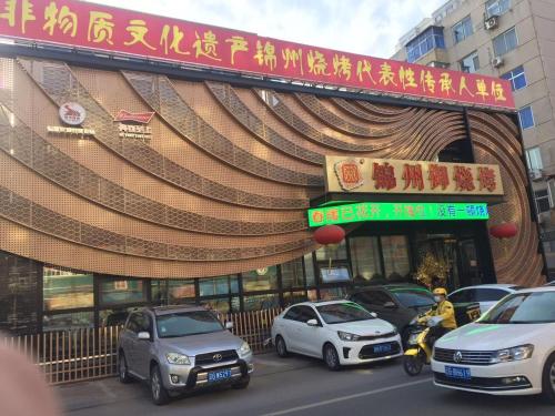a group of cars parked in front of a building at 7Days Premium Jinzhou Railway Station Branch in Jinzhou