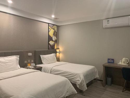 a hotel room with two beds and a desk at 7Days Premium Beijing South Railway Station Jiaomen East Subway Station Branch in Beijing