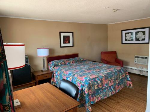 a hotel room with a bed and a chair at Stonehouse Motel and Restaurant in Truro