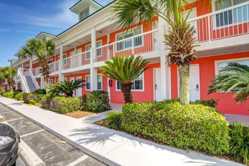 a building with palm trees in front of a street at Tropical Isle #112 in Fort Walton Beach