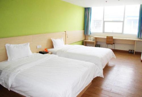 Ένα ή περισσότερα κρεβάτια σε δωμάτιο στο 7Days Inn Qintai Square