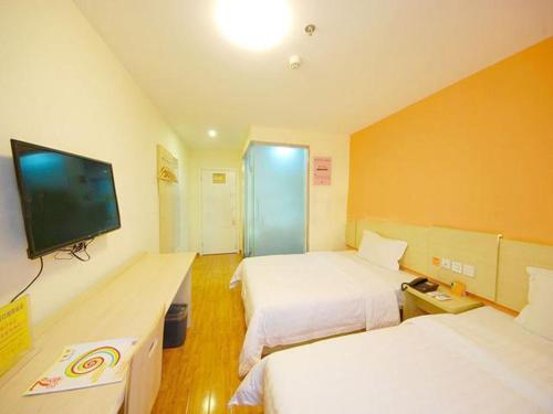 西安市にある7Days Inn Railway Station Wulukou Subway Stationのベッド2台、薄型テレビが備わるホテルルームです。
