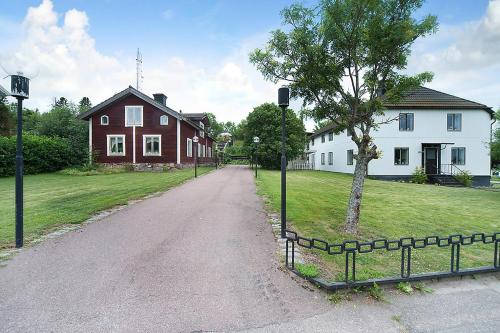 a dirt road leading to a house and a tree at Skärplinge Gästis B&B in Skärplinge
