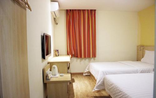 a hotel room with two beds and a window at 7Days Inn Shenyang Sanhao Street Liaozhan in Shenyang