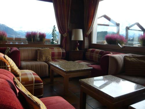 a living room with couches and tables and a window at Le Cordonant in Cordon