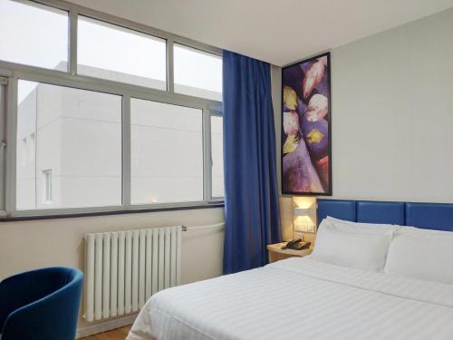 a hotel room with a bed and a window at 7Days Inn Xi'an Jiaoda Medical College Weiyi Street Subway Station in Xi'an