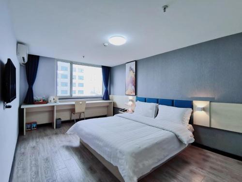 a bedroom with a large bed and a desk at 7Days Inn Xi'an North Street Subway Station Lianhu Park in Xi'an