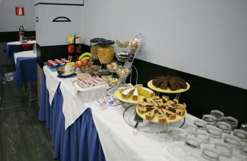 a table with a buffet of food and desserts at Hotel Magenta in Florence