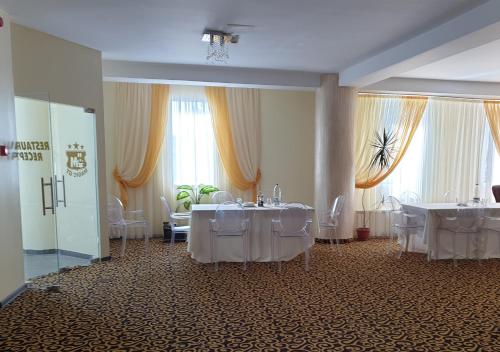 a banquet hall with white tables and chairs at Hotel Magic - City Center in Piteşti